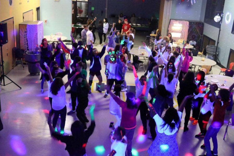 Freshmen+dance+in+Cafeteria+C%2C+illuminated+by+black+light+and+glow+sticks.
