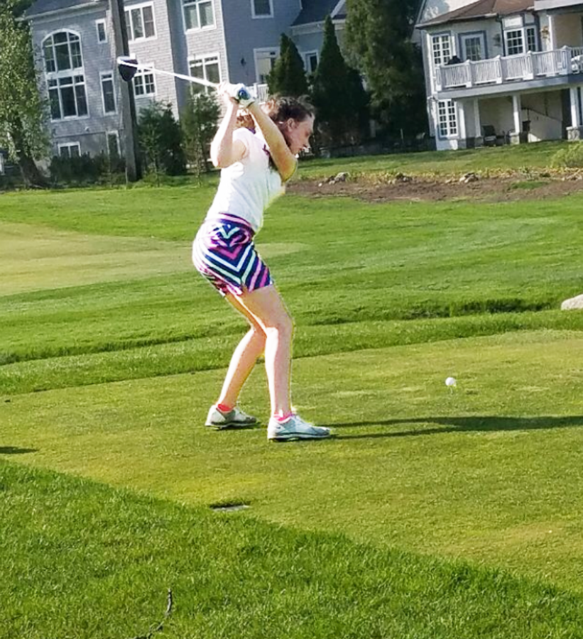 Sophomore+Catherine+Taubner+takes+to+the+green+as+she+practices+her+swing.