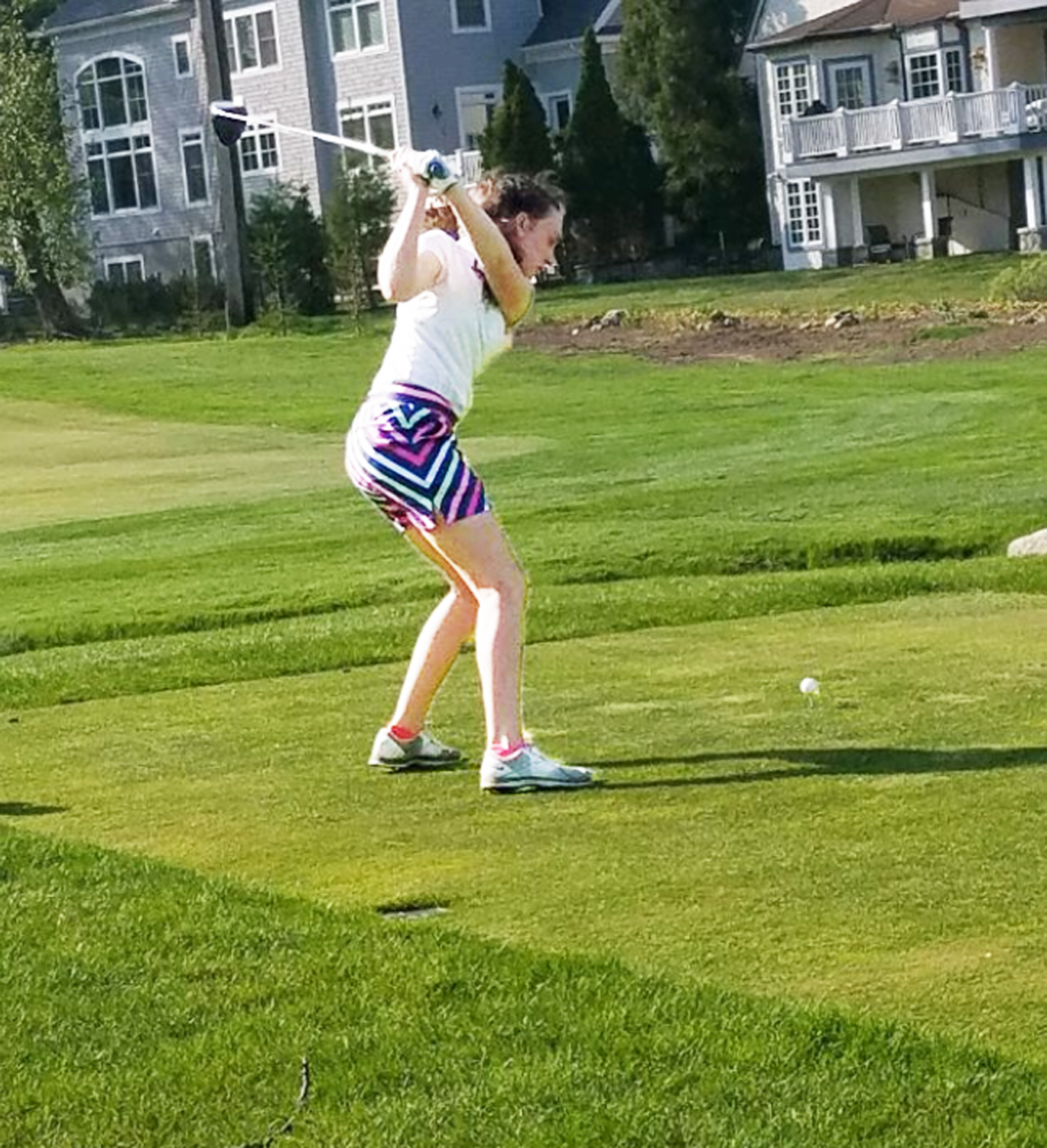 Sophomore Catherine Taubner takes to the green as she practices her swing.