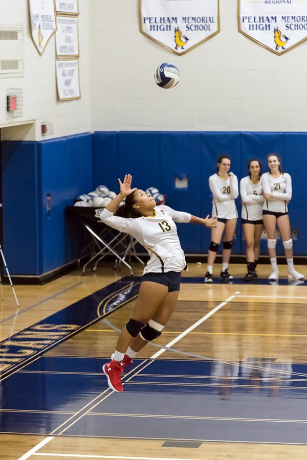Senior Nora Tahbaz jumps high in the air to serve the ball.