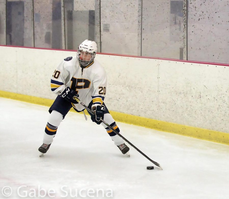 Sophomore Michael Mitrione skates down the ice versus St. Mary’s.