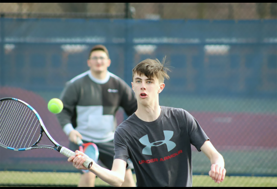 Sophomore Gavin Fear follows through on a volley during a tennis practice.