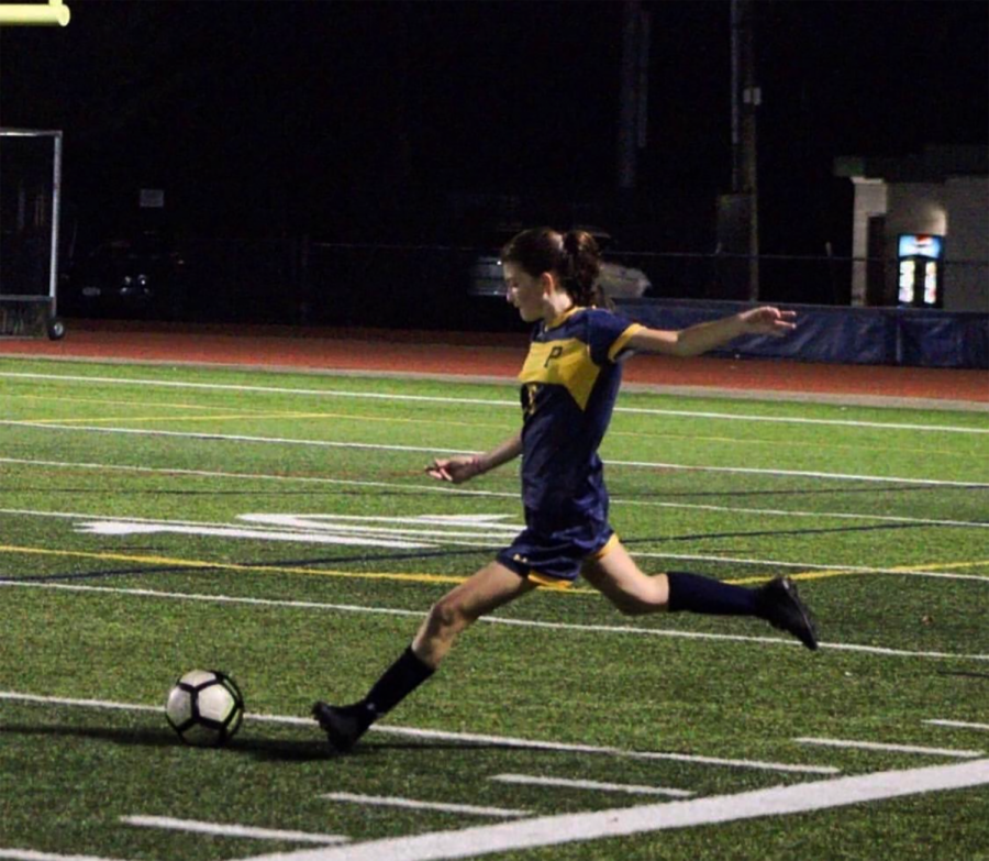 Junior Catie Woods boots the ball across the field.