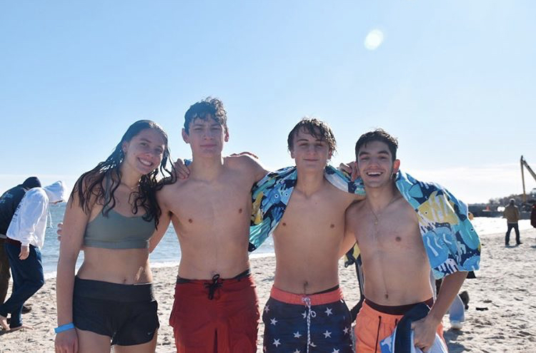 (l to r) Seniors Charlotte Howard, Cameron Kleinberger, Luke DeVivo, and Anthony Romano stand freezing on the beach after their plunge.