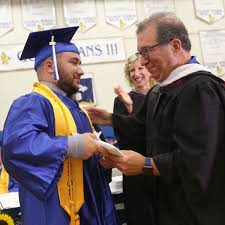 Thomas Imperato (r) proudly bestows the diploma to son Sam Imperato in June 2018.