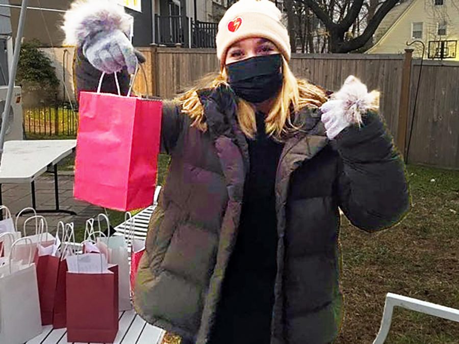 A masked club member shows of a bag of goodies, destination --  Bayberry Care Center.