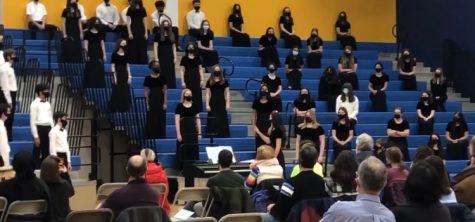 Vocalists stand six feet apart on the Middle School Gym bleachers in order to safely sing in Winter Concert 2021.