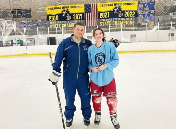 Karame stands on the ice with Coach Cambria